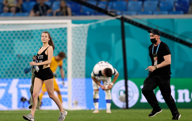 Trận đấu giữa Bỉ và Phần Lan tại lượt trận cuối bảng B EURO 2020 đã bị gián đoạn bởi một sự cố hy hữu. Những hình ảnh trực tiếp cho thấy một người phụ nữ mặc áo thun màu đen cùng chiếc quần ngắn bó sát chạy vào sân. Trên áo của cô có in dòng chữ WTF Coin.