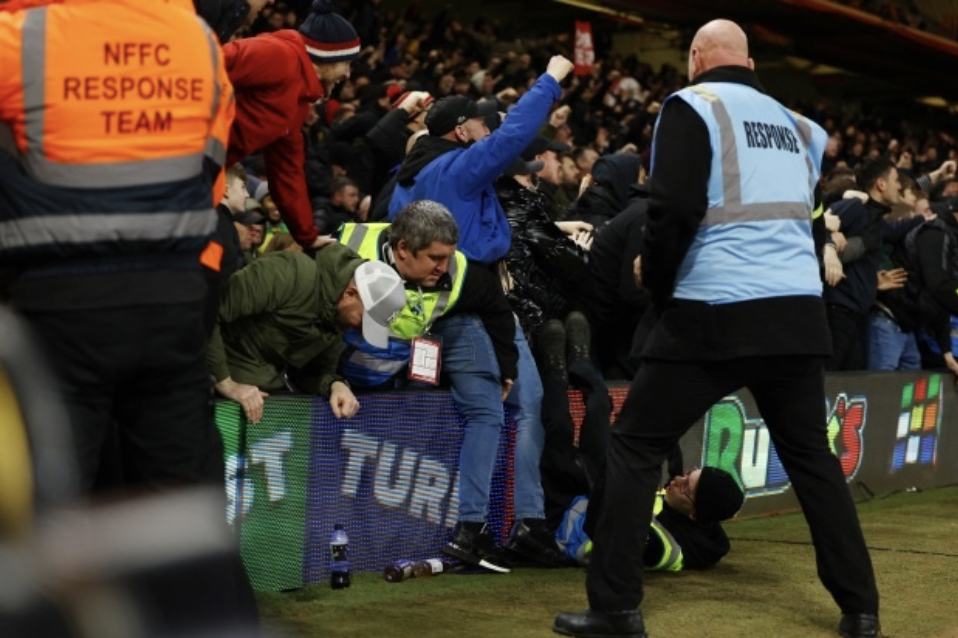 Nhân viên an ninh tại sân City Ground phản ứng nhanh trước đám đông cuồng nhiệt. Trong khung hình, có thể nhìn thấy một người ngã lăn xuống đất.