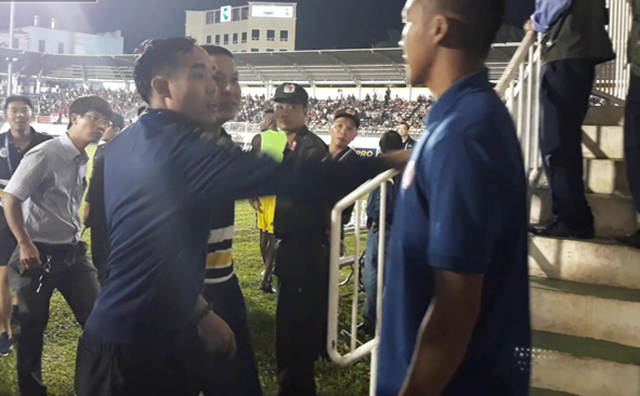 Người "lạ mặt" (bên phải) chặn đường HLV Chu Đình Nghiêm.