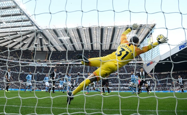 Thủ thành Ederson bay người trong vô vọng sau cú sút xa quân bình tỷ số 2-2 của Jonjo Shelvey trong trận đấu giữa Newcastle với Man City. Hiện các nhà ĐKVĐ nước Anh đã bị Liverpool bỏ xa đến 11 điểm trên BXH.