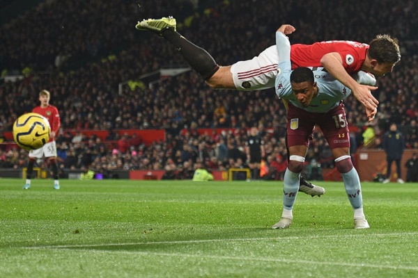 Harry Maguire tranh chấp với Ezri Konsa của Aston Villa. Quỷ đỏ đã để đối thủ cầm hòa 2-2 trên sân nhà.