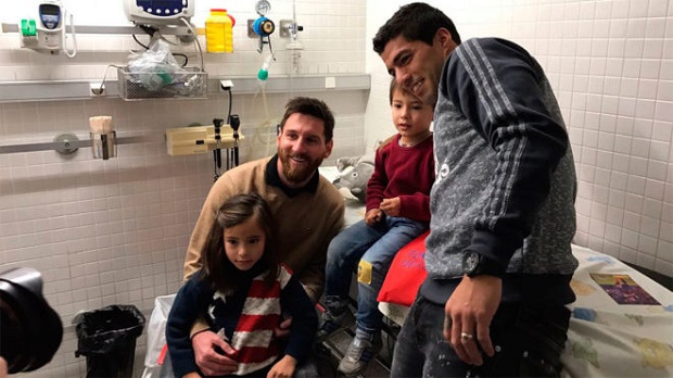 Messi và Suarez bên cạnh các em nhỏ. Ảnh: Marca