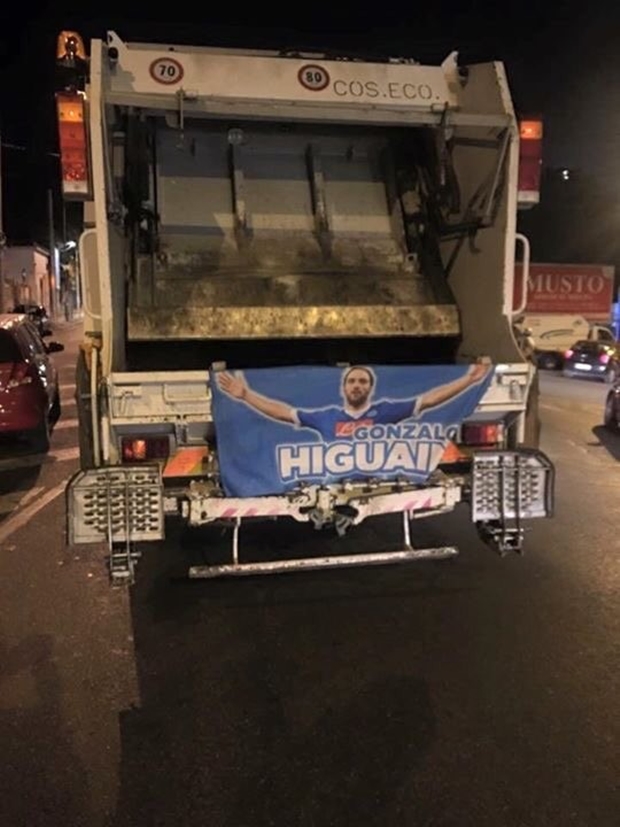 Lá cờ in hình chân sút có biệt danh El Pipita bị treo vào đuôi xe chở rác.