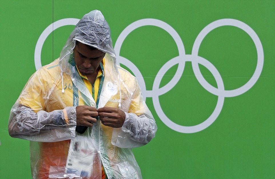 Cũng phải thừa nhận, thời tiết không thuận lợi cũng là một nguyên nhân khiến lượng khán giả thưa thớt. Một nhân viên phục vụ Olympic đang mặc áo mưa. Ảnh: Internet.