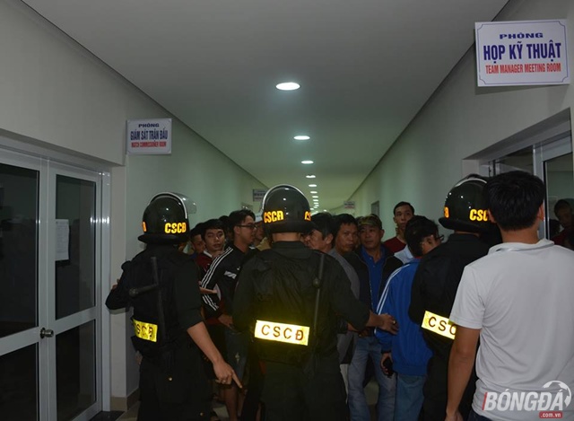 CSCĐ đang cố gắng ngăn chặn những cổ động viên tràn vào sân. Ảnh: Đức Trường.
