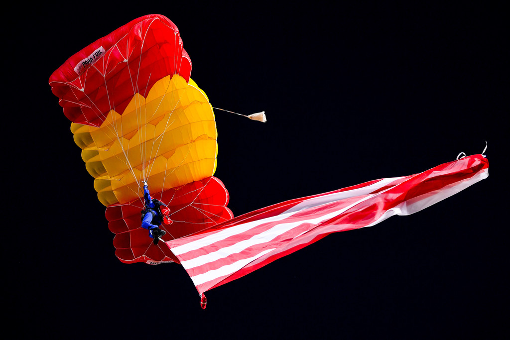 Một thợ nhảy dù biểu diễn đã cầm lá cờ Atletico tung bay trên không trung.