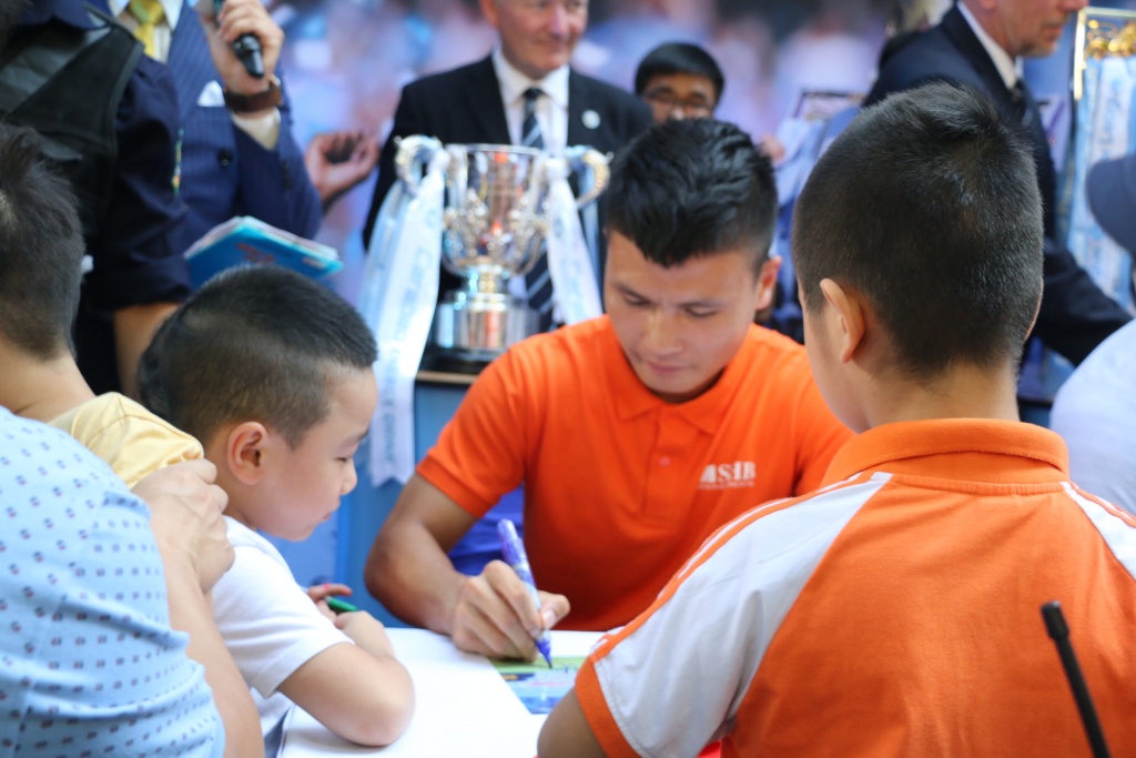 Quang Hải nhiệt tình kí tặng các fan.
