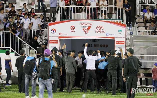 Phải cần đến lực lượng an ninh hộ tống, tổ trọng tài mới ra được sân một cách an toàn. Khán giả bóng đá phố núi đòi xử đẹp trọng tài chính Trần Xuân Nguyện, cùng những lời "vàng ngọc" hướng đến tổ trọng tài điều khiển trận đấu. Ảnh: Duy Anh.